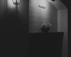 Mustvalge foto, kus latern valgustab teenindusletti või avatavat aknaluuki, mille kohal on silt "Avatud". Autor: Priit Suve. Mustvalge foto: Priit Suve jäädvustus valgustatud teenindusavast või letist kirjaga "Avatud".